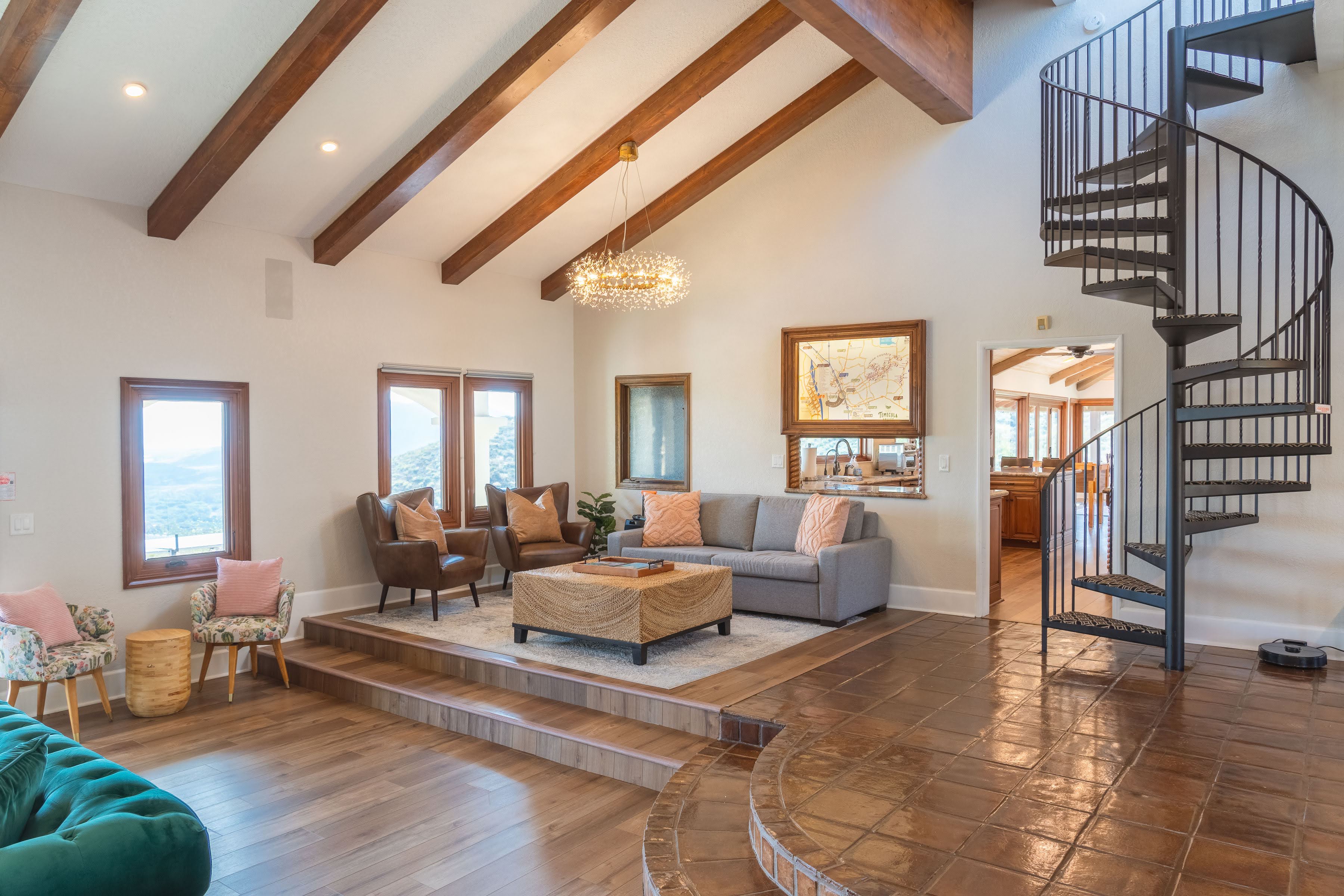 Main house interior showcasing vaulted wood-beam ceilings and grand fireplace
